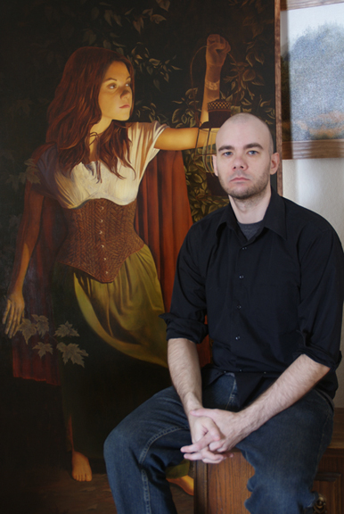 The artist sitting next to a painting.
